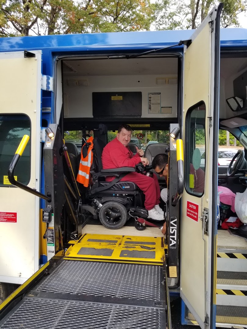 Ronnie using a lift platform to enter an GoRaleigh Access paratransit van
