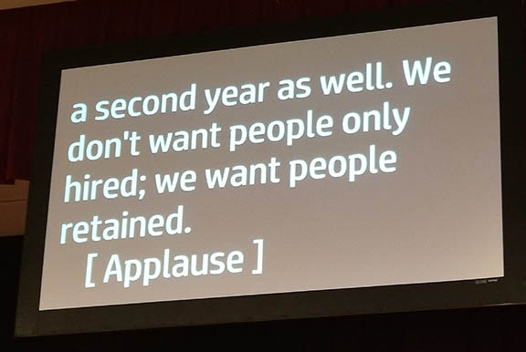 Photo of CART captioning at the National ADA Symposium reading, “We don’t want people only hired; we want people retained.  [Applause]"