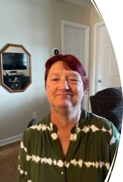 Phot of Donna Spears, a white female with short red hair wearing a dark green and white striped shirt.